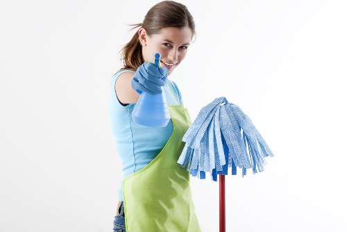 Cleaner wearing gloves and using safe equipment in a home setting