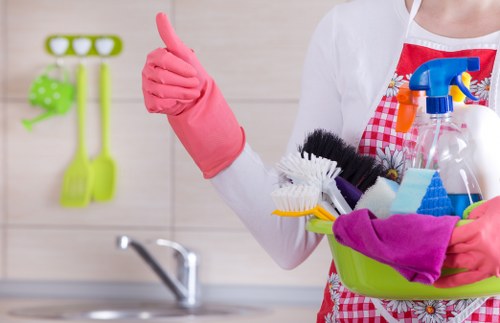 Cleaner tidying a shared workspace in a London building